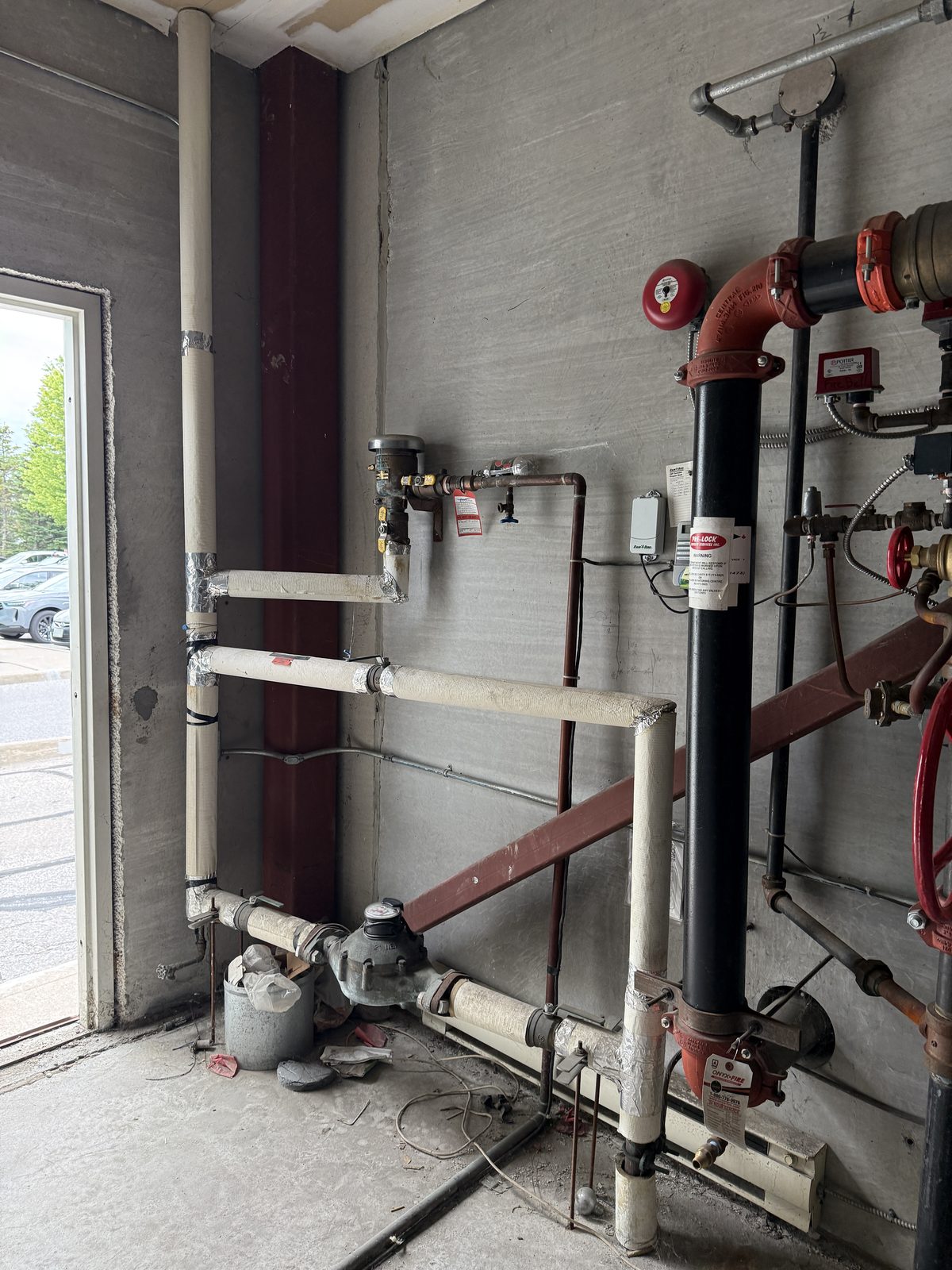 The water service as it was: meter and piping beside the door, no assembly on the riser