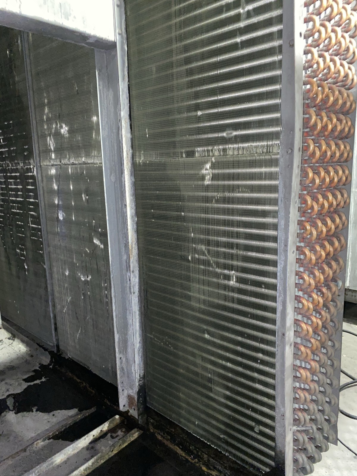 The evaporator coil bank after cleaning, wet, with the copper return bends at the right