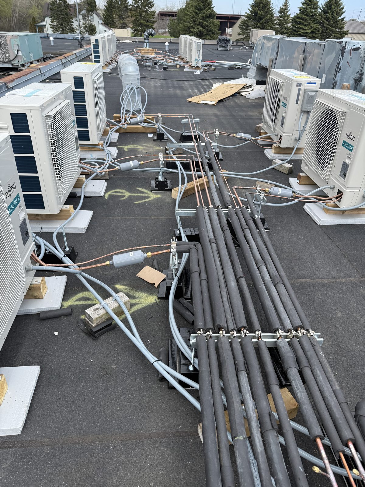 Refrigerant line sets grouped on a rooftop installation