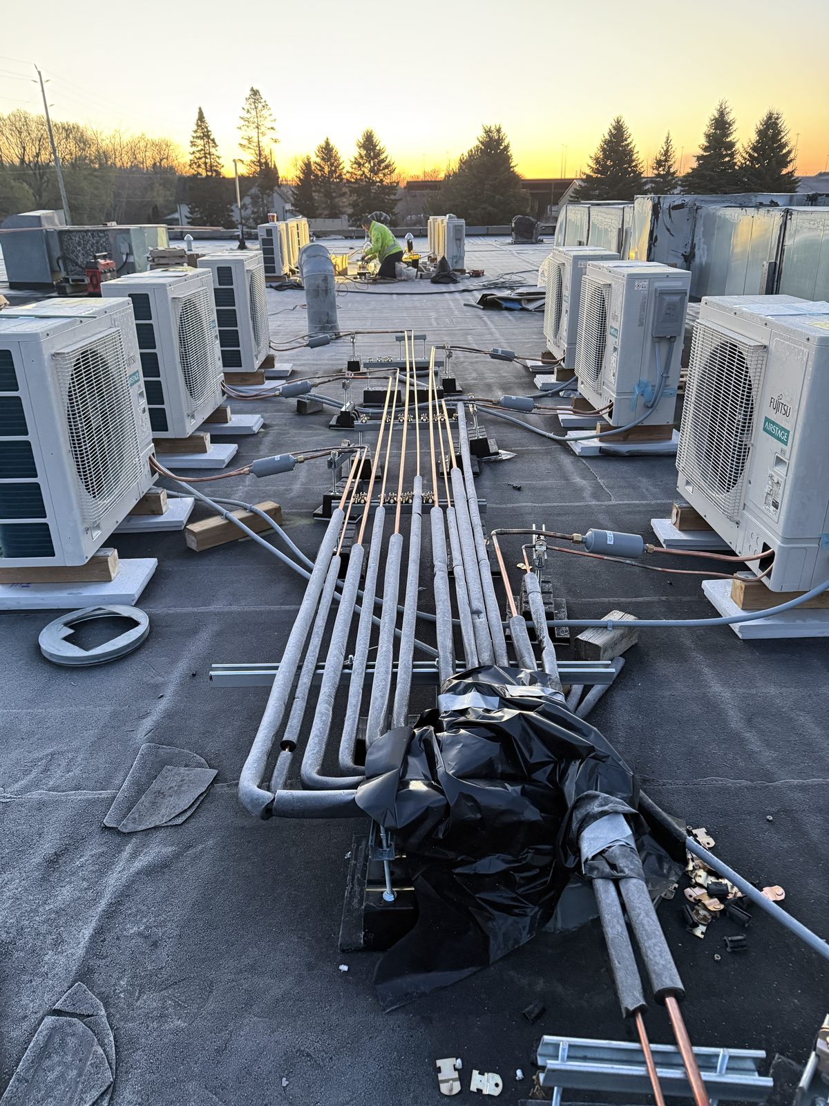 Insulated line sets running across a roof at sunset