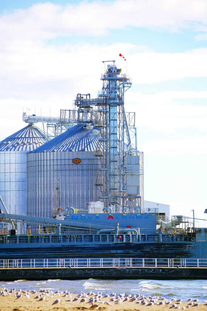 Industrial silos by the water in Oshawa Ontario on a partly cloudy day. Backflow Prevention Oshawa services.