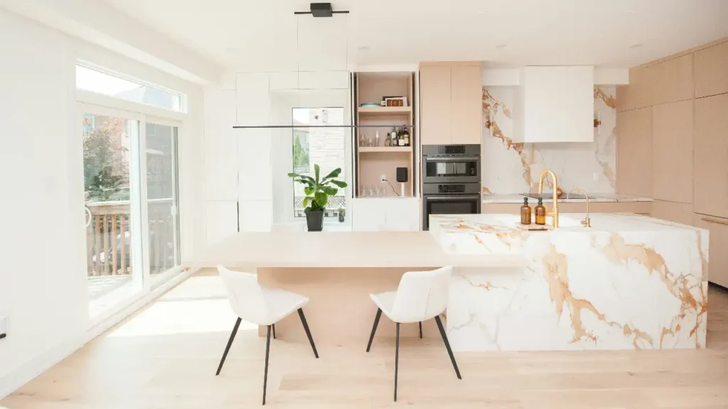 Contemporary kitchen with marble island, gold faucet and dining space