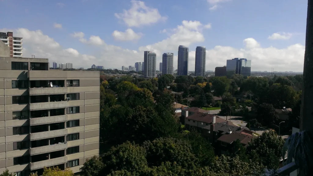 View of Scarborough skyline with high-rise residential and office buildings surrounded by trees and suburban houses